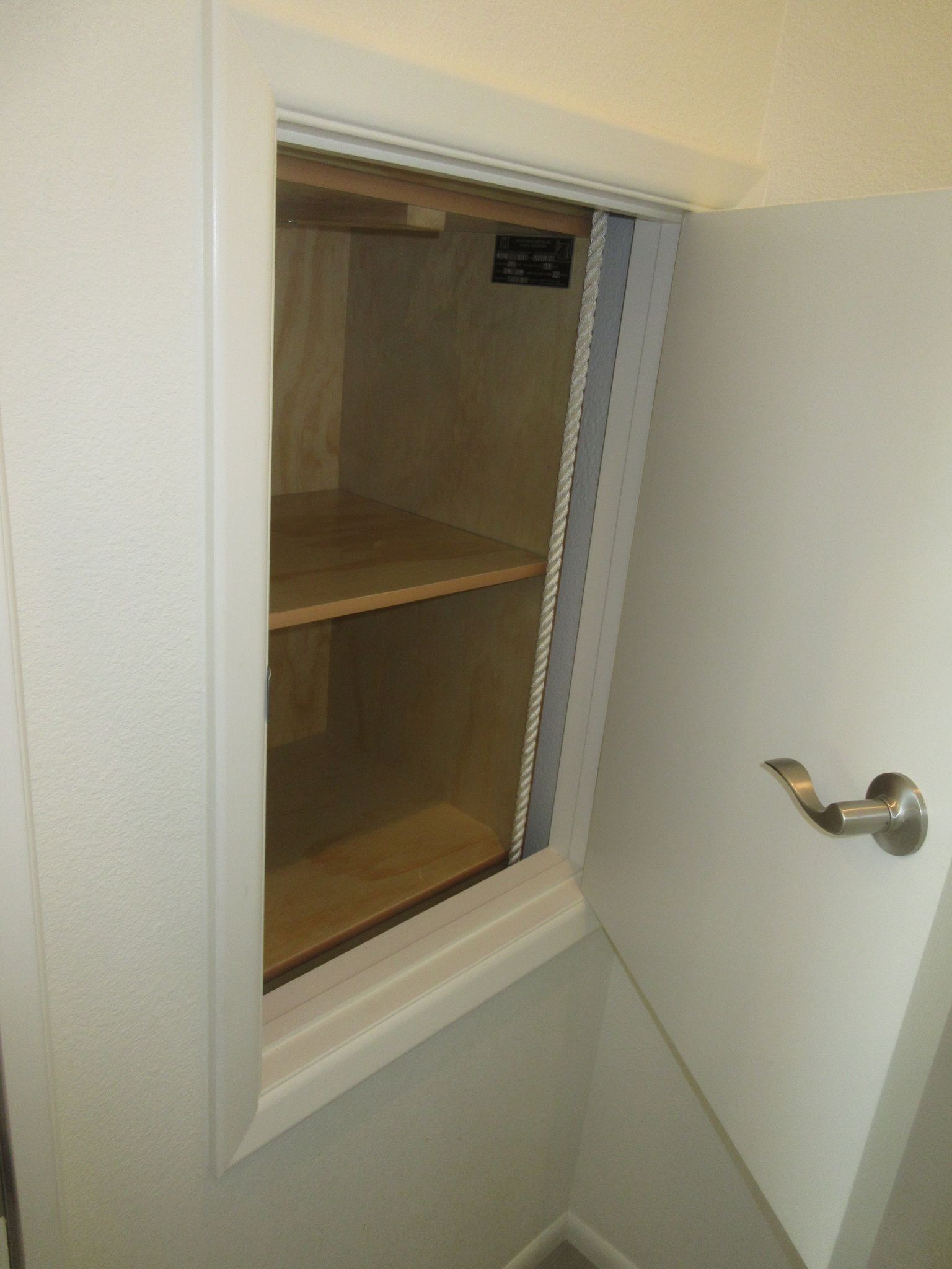 A white door with a window and shelves inside of it