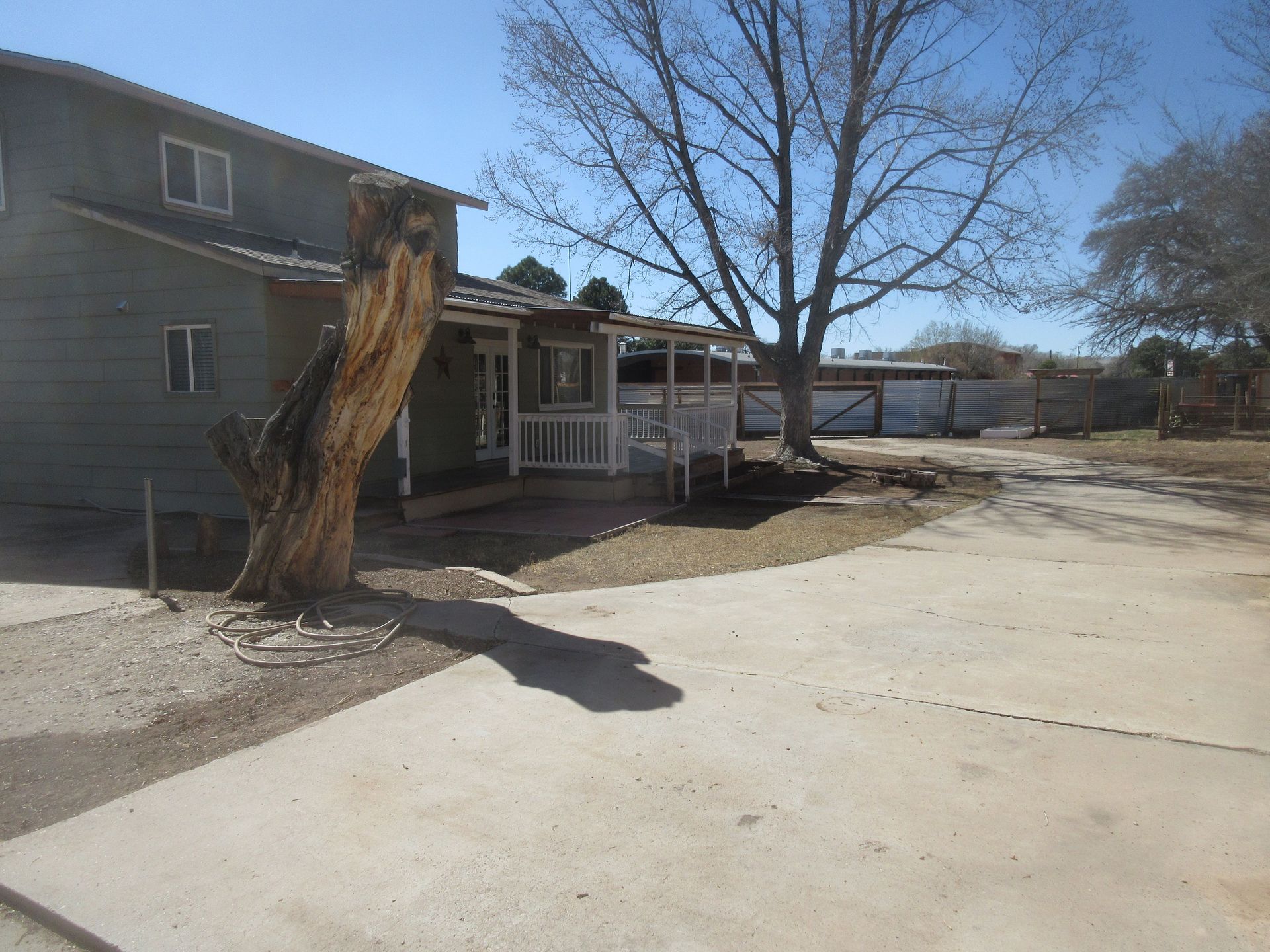 A house with a porch and a tree in front of it