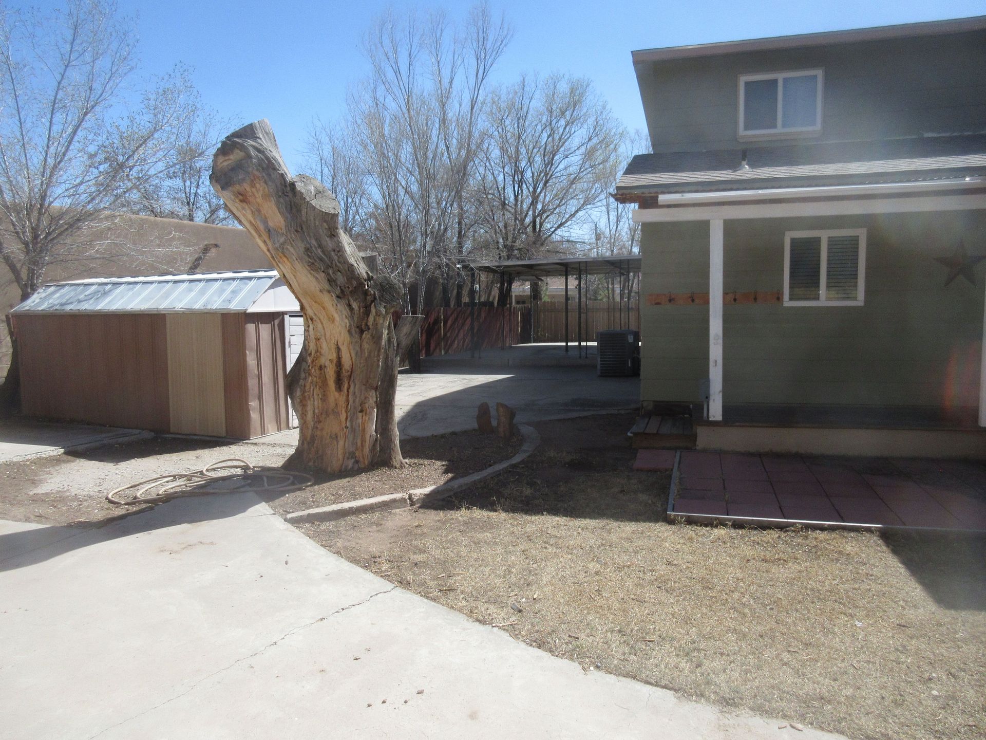 A house with a tree stump in front of it