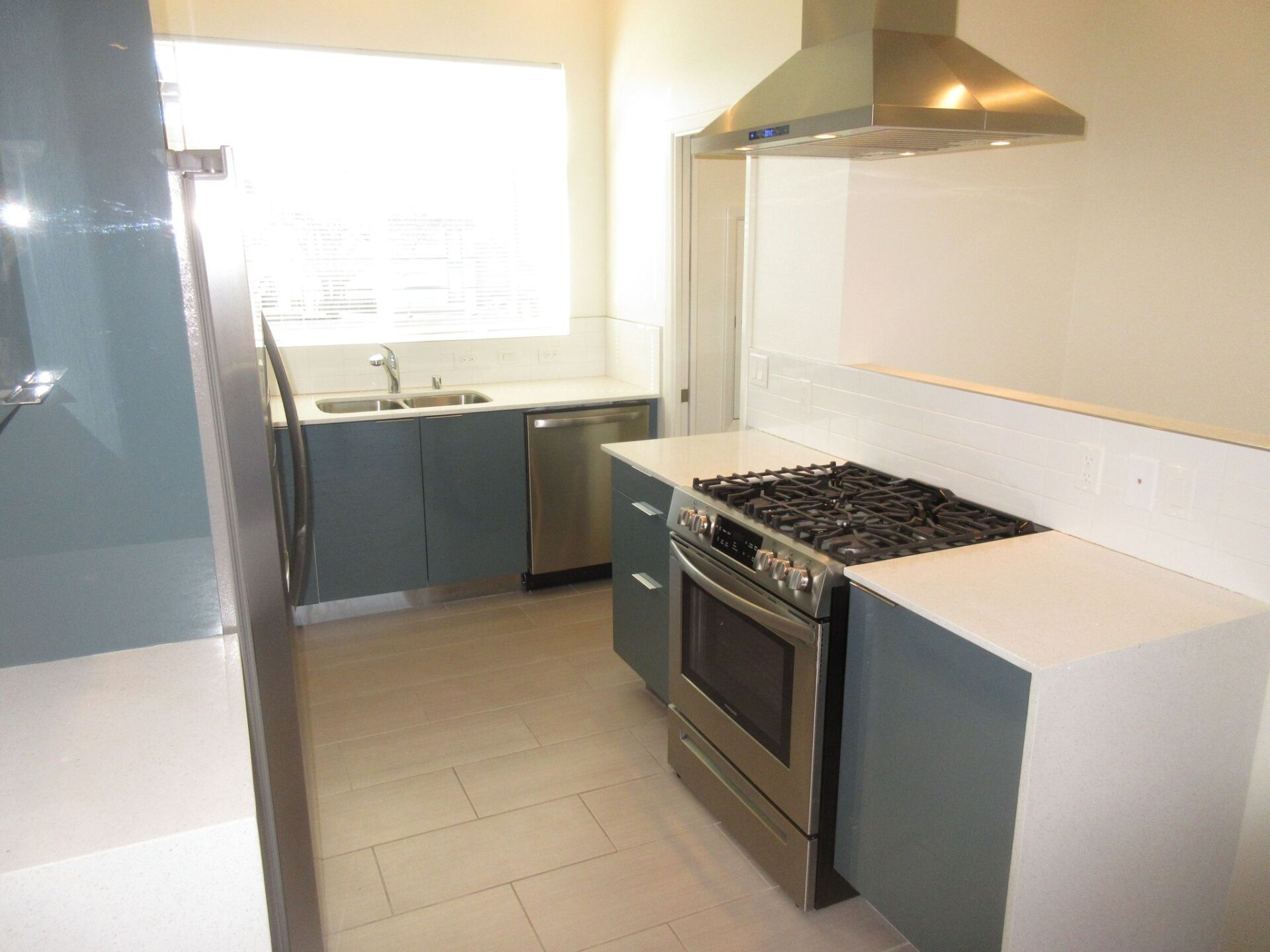 A kitchen with stainless steel appliances and blue cabinets