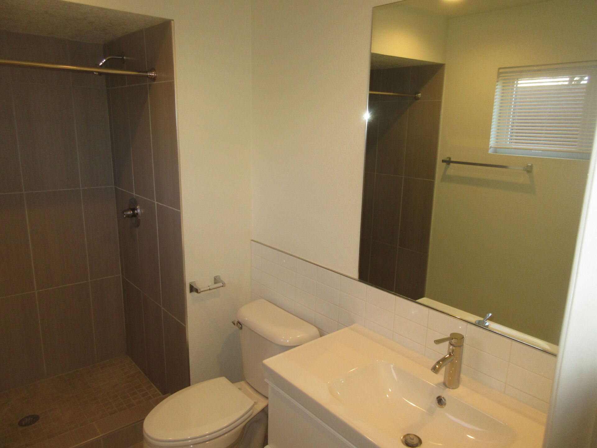 A bathroom with a toilet a sink and a mirror