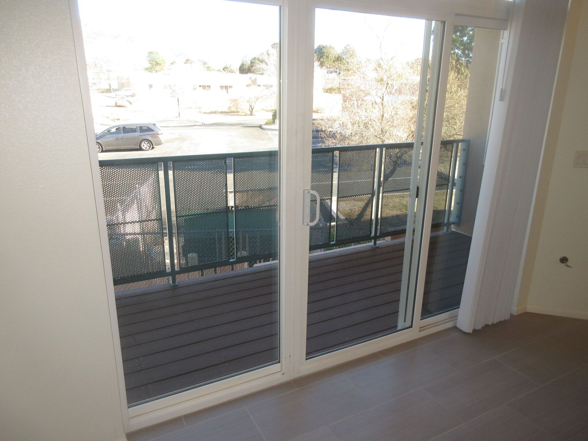 An empty room with sliding glass doors leading to a balcony