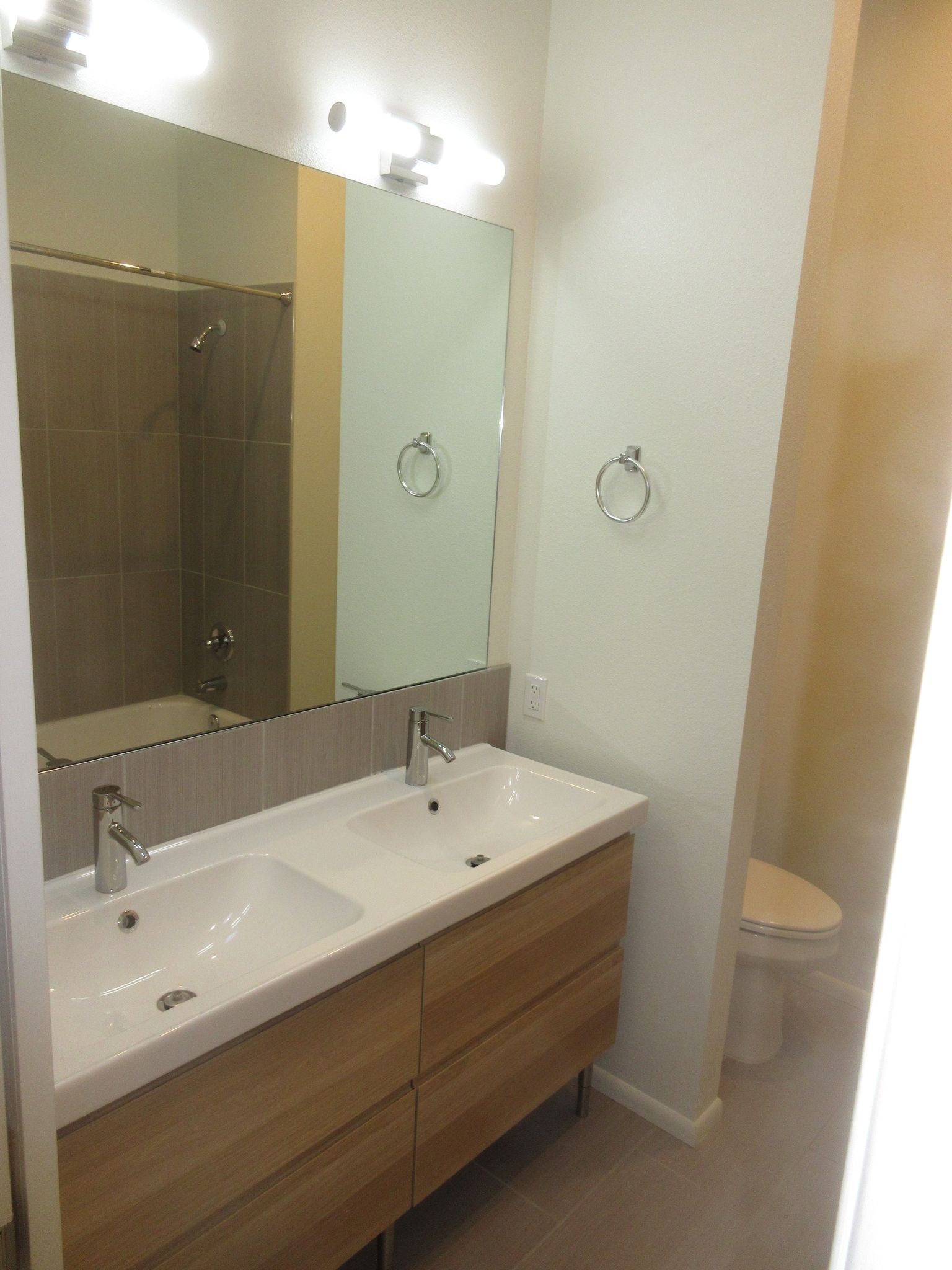 A bathroom with two sinks and a toilet