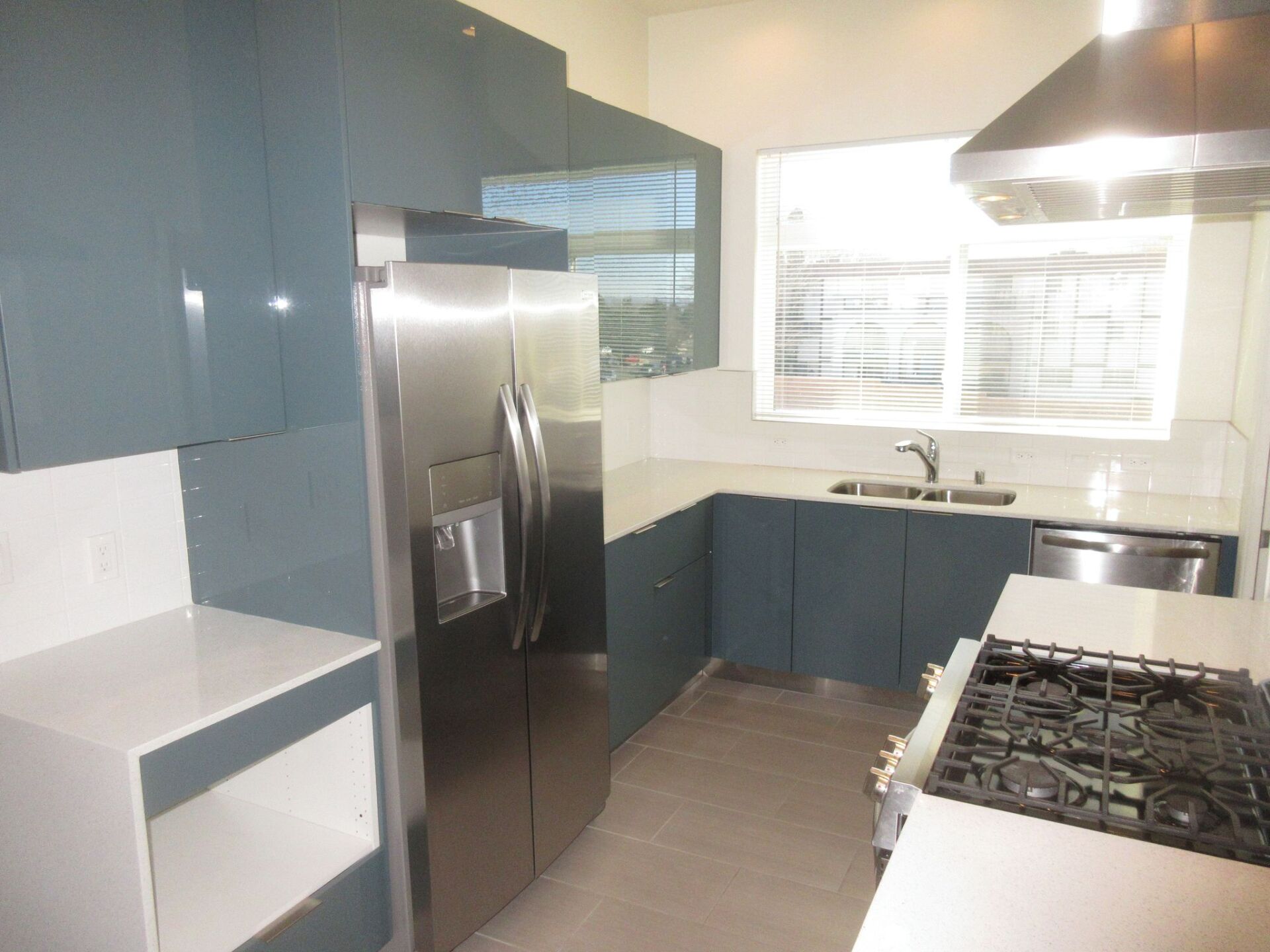 A kitchen with stainless steel appliances and blue cabinets