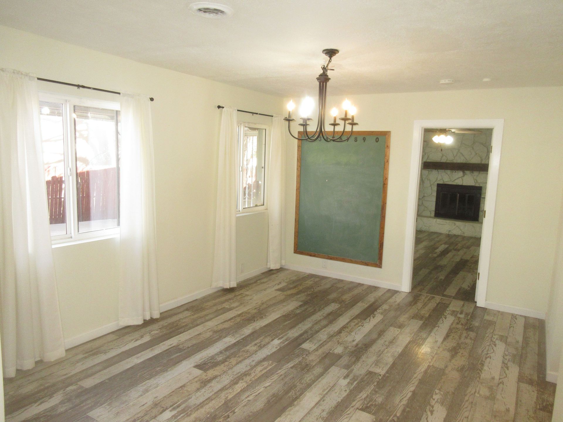 There is a chalkboard on the wall in the living room.