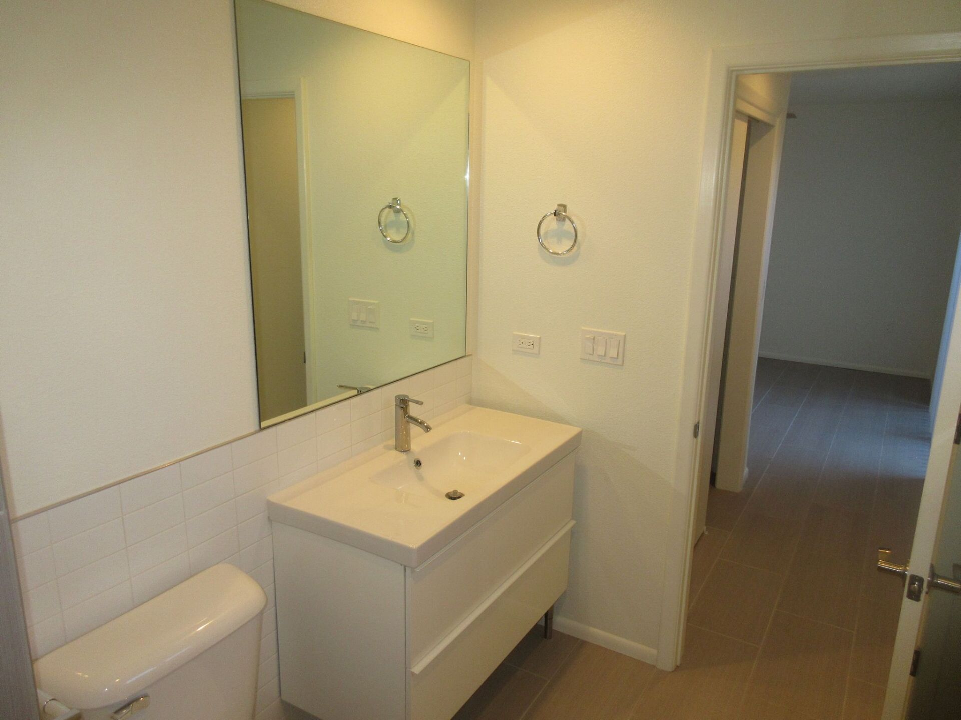 A bathroom with a toilet a sink and a mirror