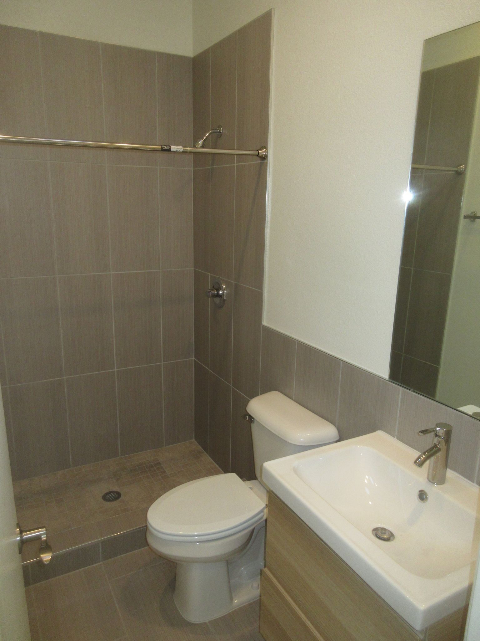 A bathroom with a toilet , sink and shower