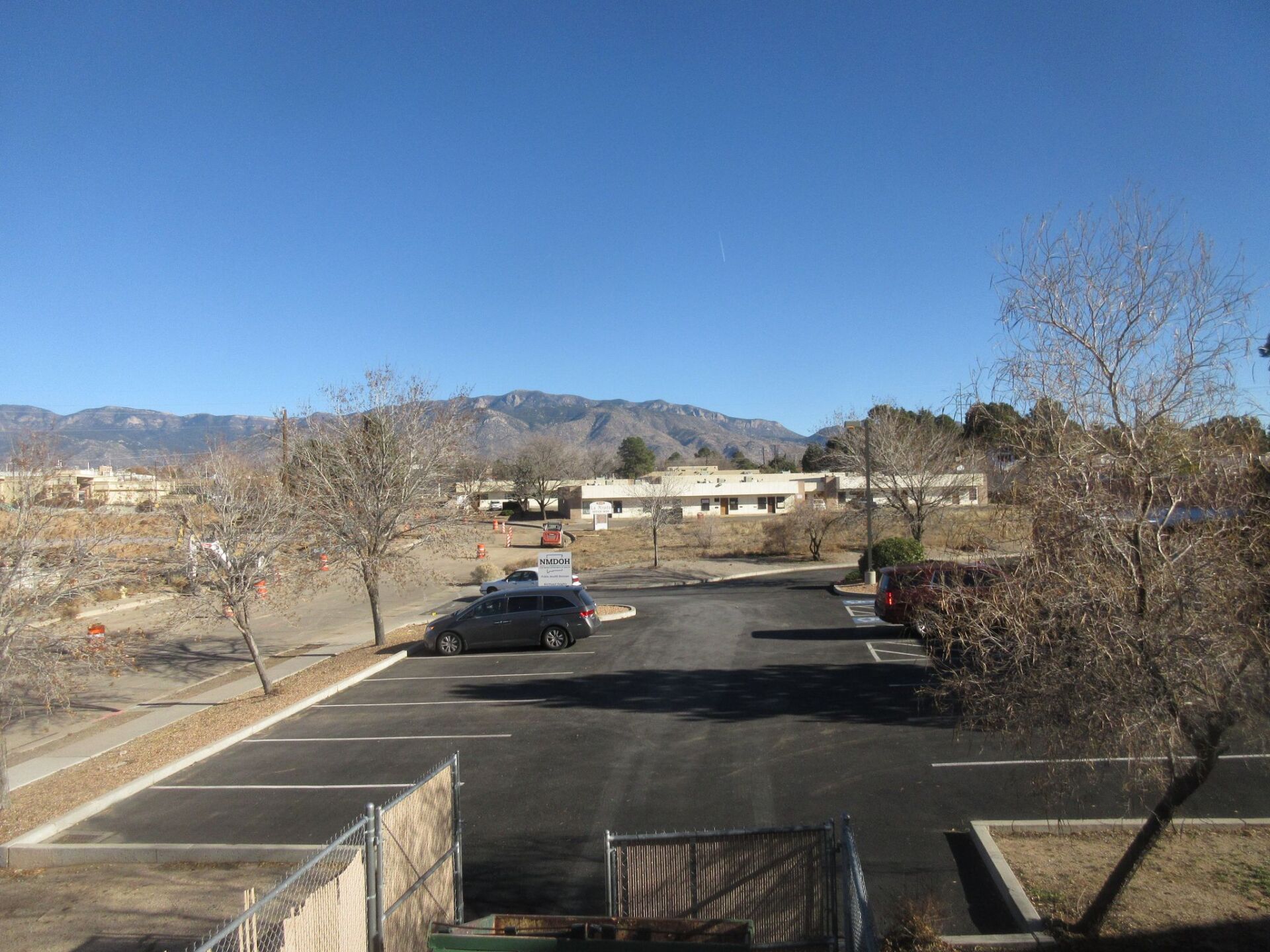 A parking lot with cars parked in it and mountains in the background