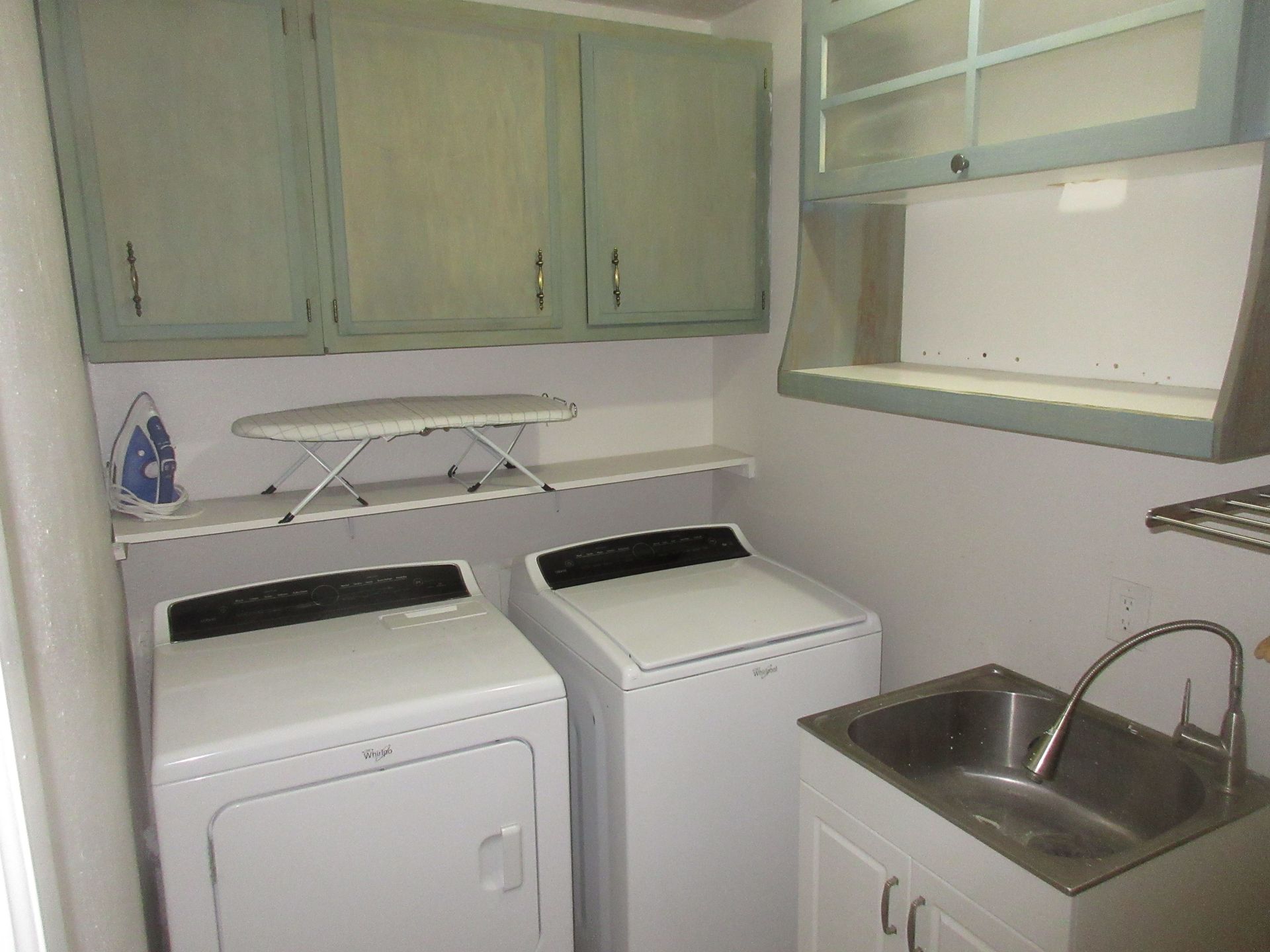 A laundry room with a washer and dryer and a sink