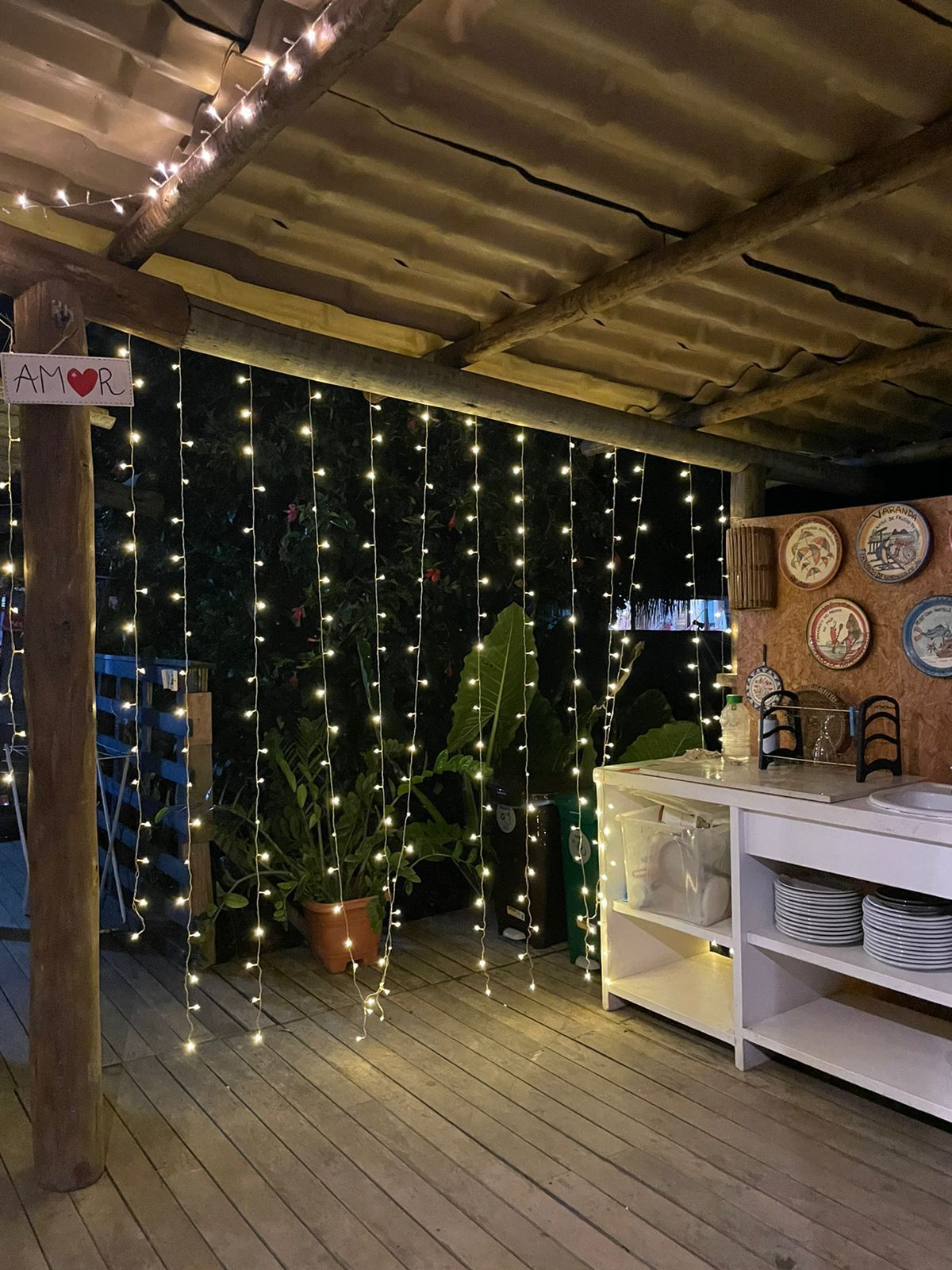 Um edifício com uma cerca na frente e uma entrada de tijolos que leva até ele.