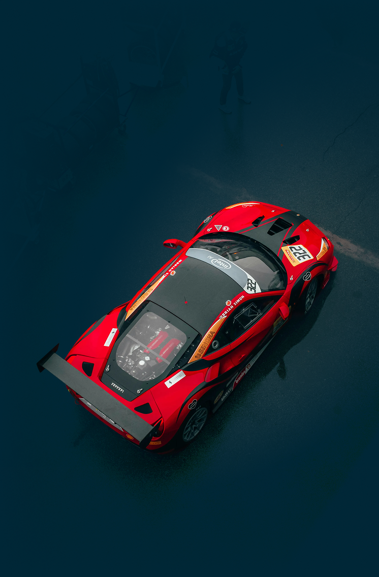 Red race car with black accents on a dark blue surface.