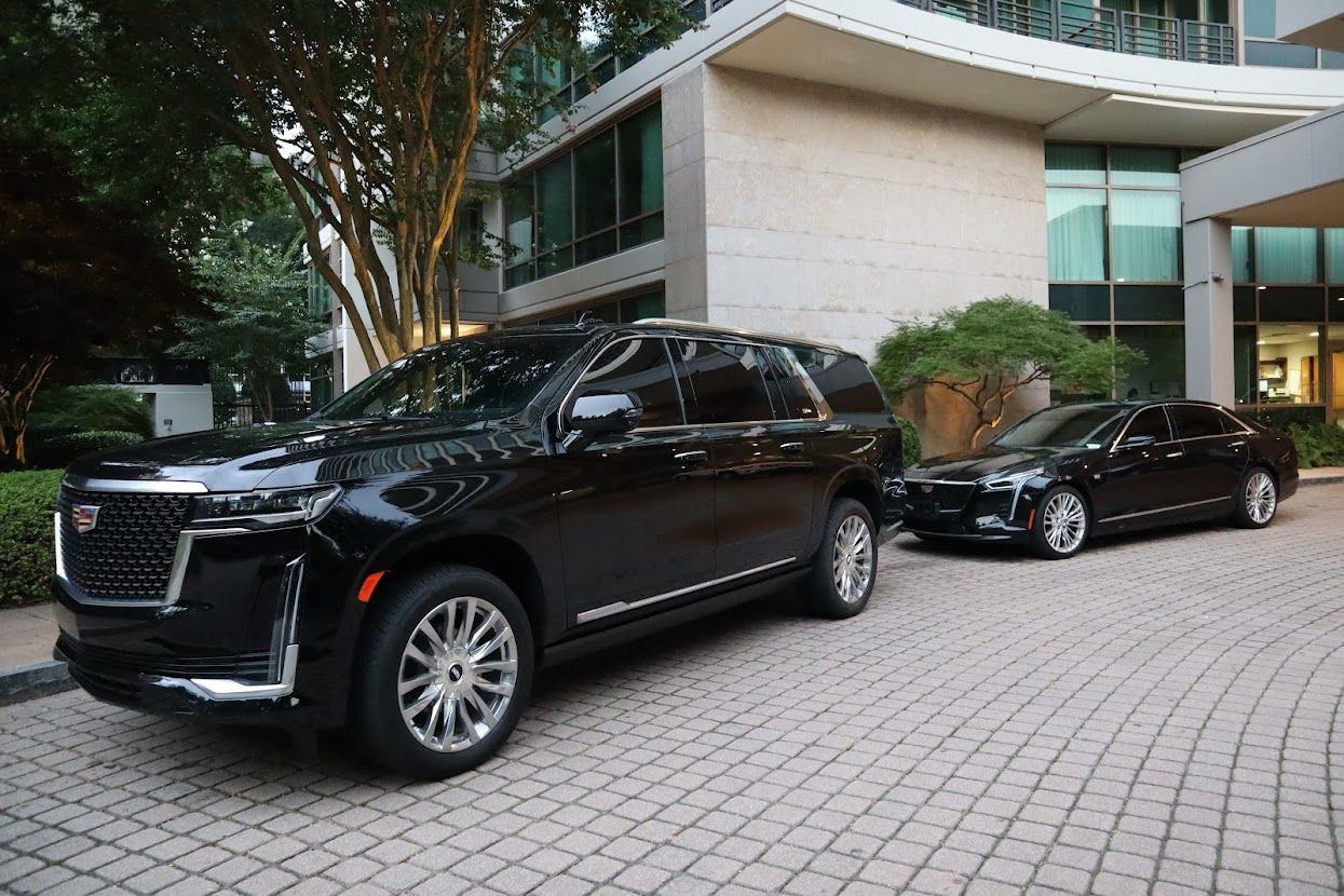 Atlanta private car service featuring black Escalade SUV and Cadillac CT6 waiting curbside at luxury residence
