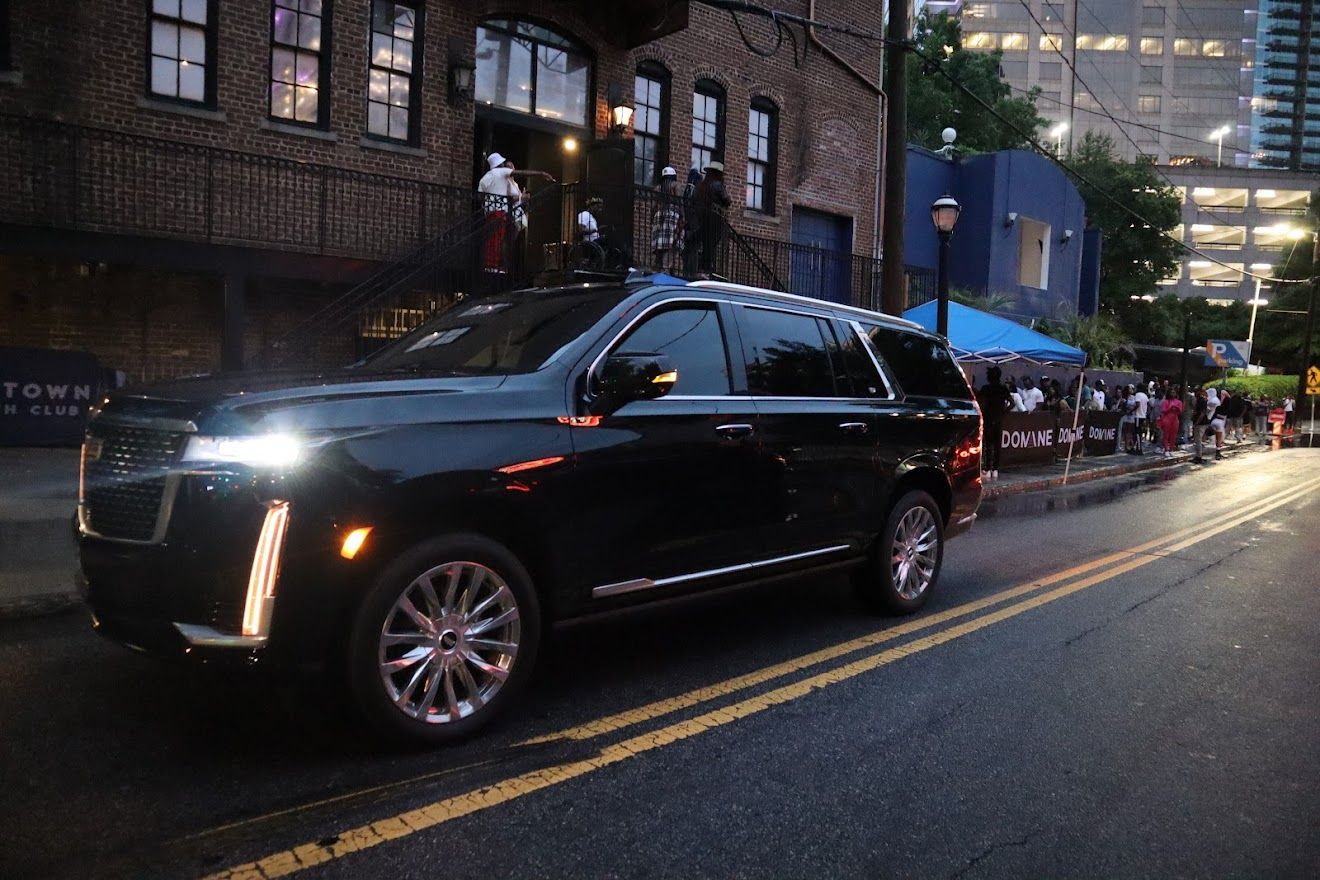 Black Cadillac Escalade on Atlanta street at night for private car service and VIP transportation
