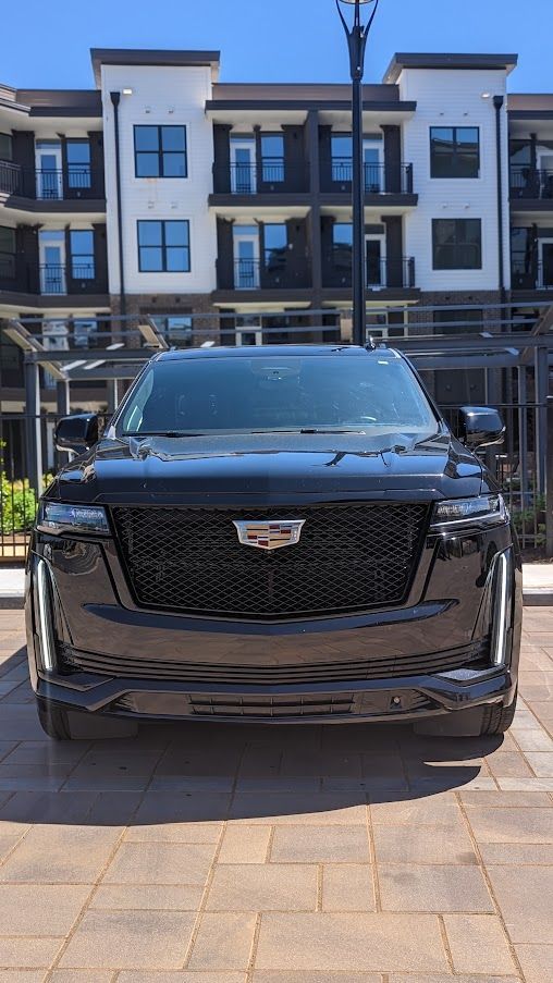 Black Cadillac Escalade luxury car service outside upscale apartment complex in Atlanta
