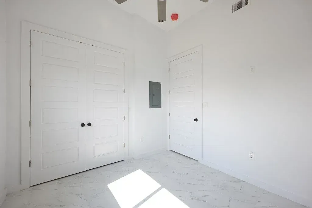 a ceiling fan in the corner of the newly painted room