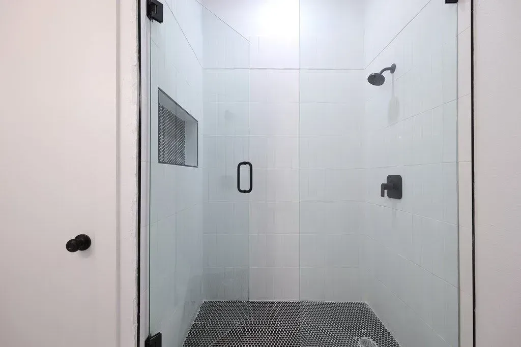 a newly remodeled bathroom with a walk in shower with a glass door