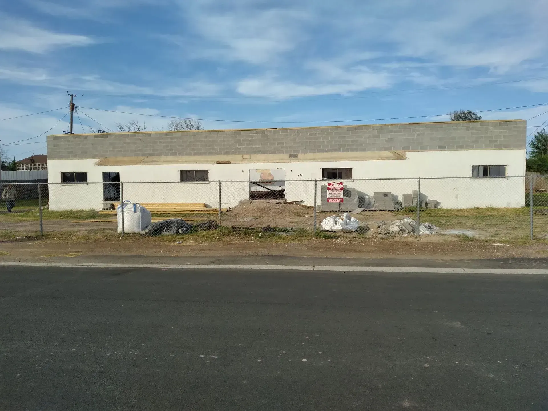 a large white building with a no parking sign in front of it