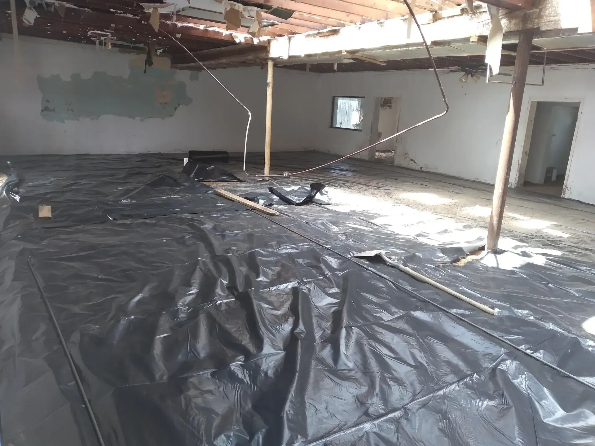 an empty room with a black tarp on the floor