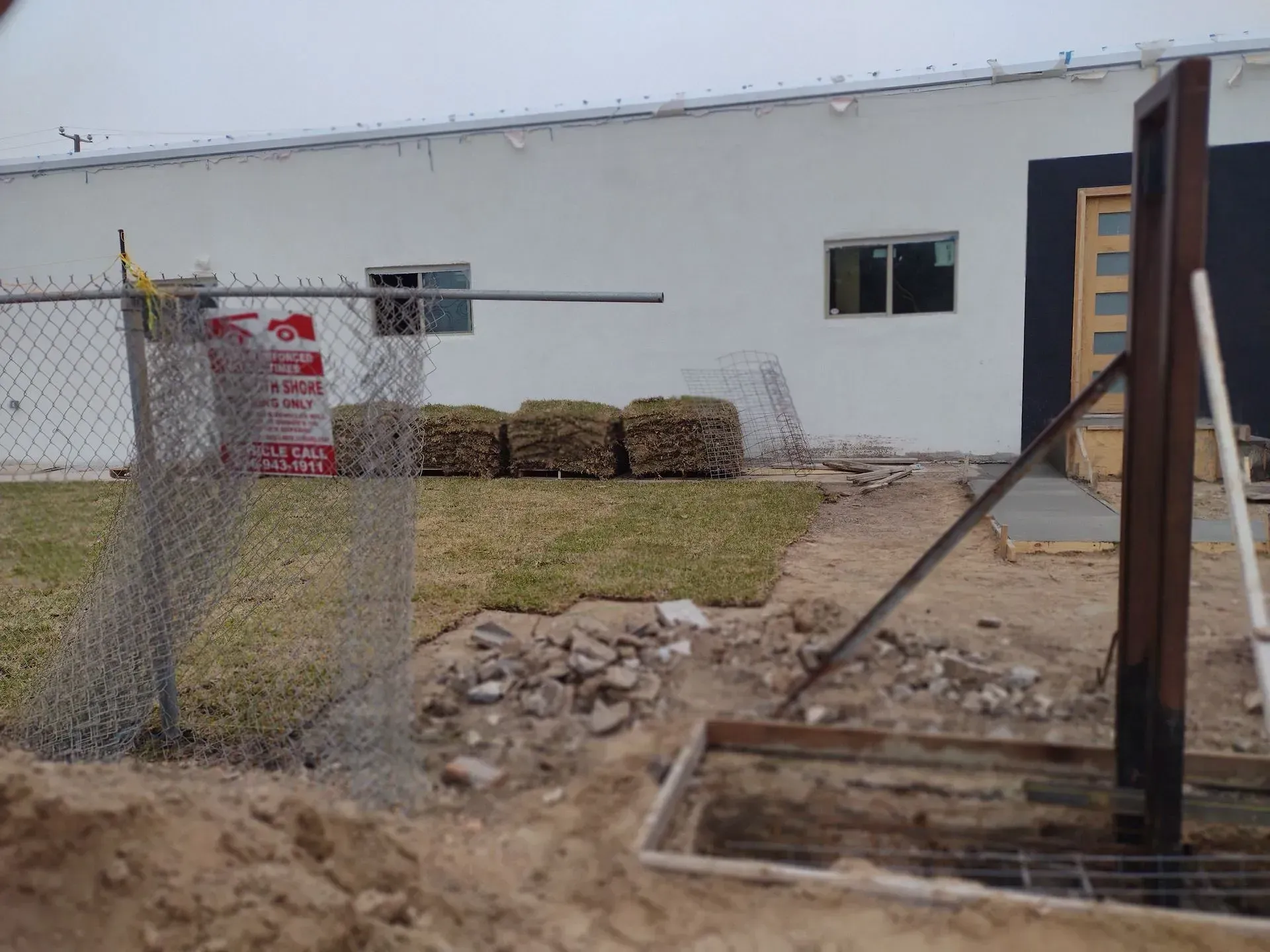a chain link fence is in front of a white building