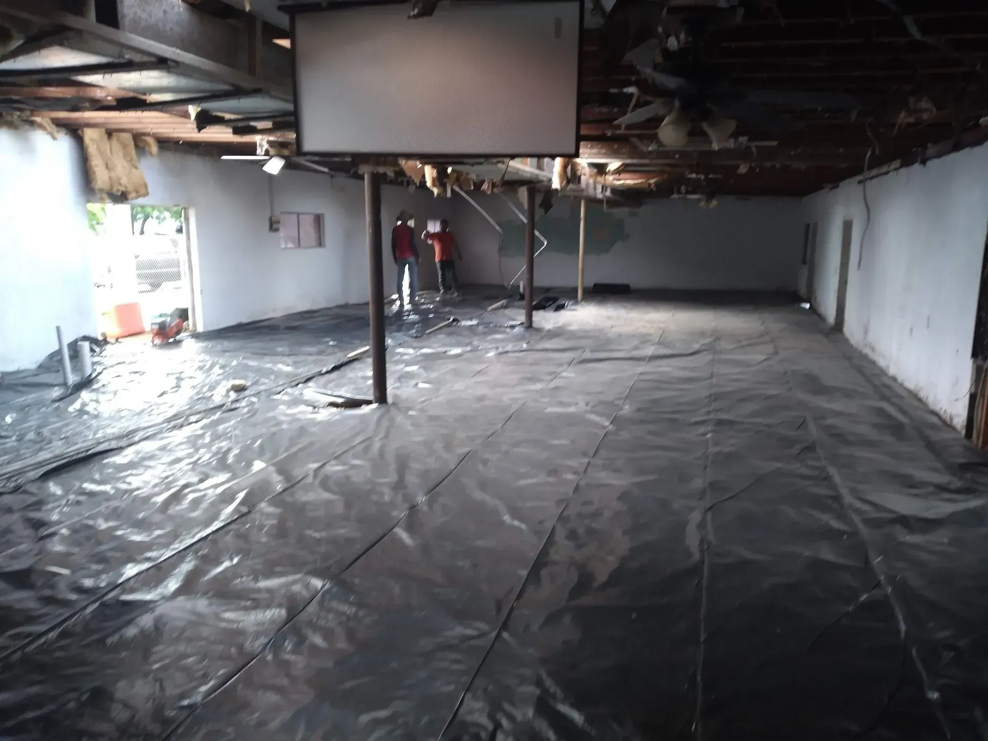 a large empty room with a black tarp on the floor