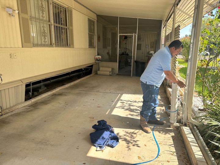 a man is kneeling down in front of a brick building