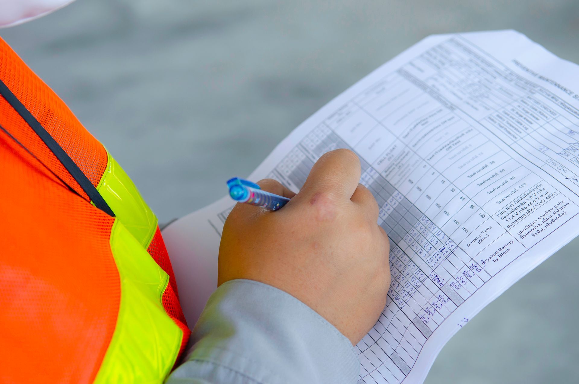 Una persona está escribiendo en un trozo de papel con un bolígrafo.