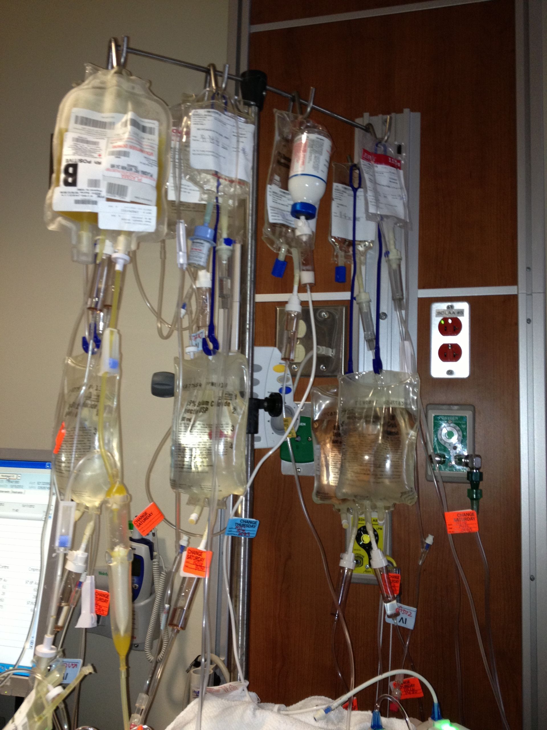 A hospital room with a lot of iv drips including one that has the number 8 on it