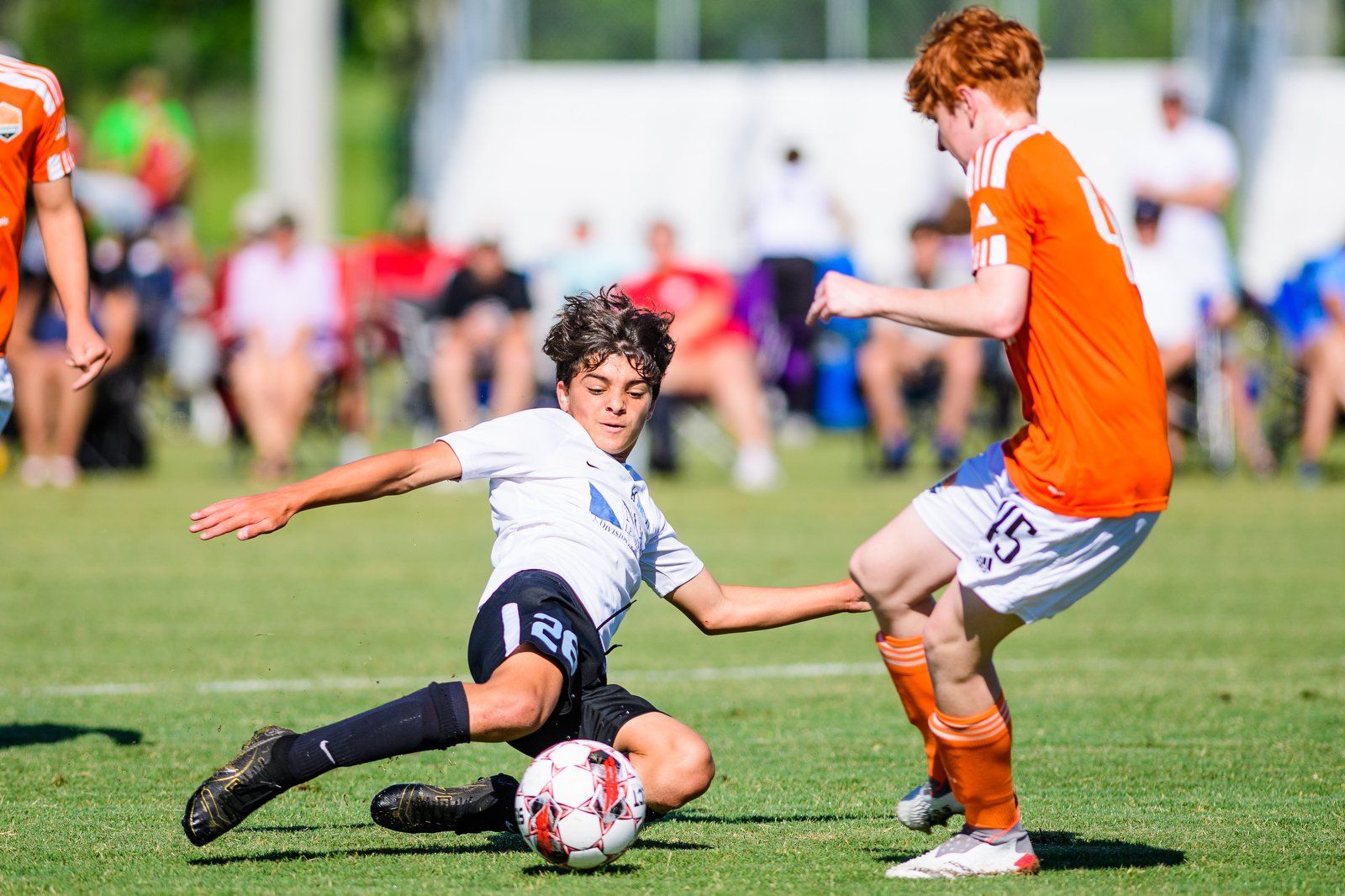 Male soccer player for Mandeville Soccer Club slide tackling