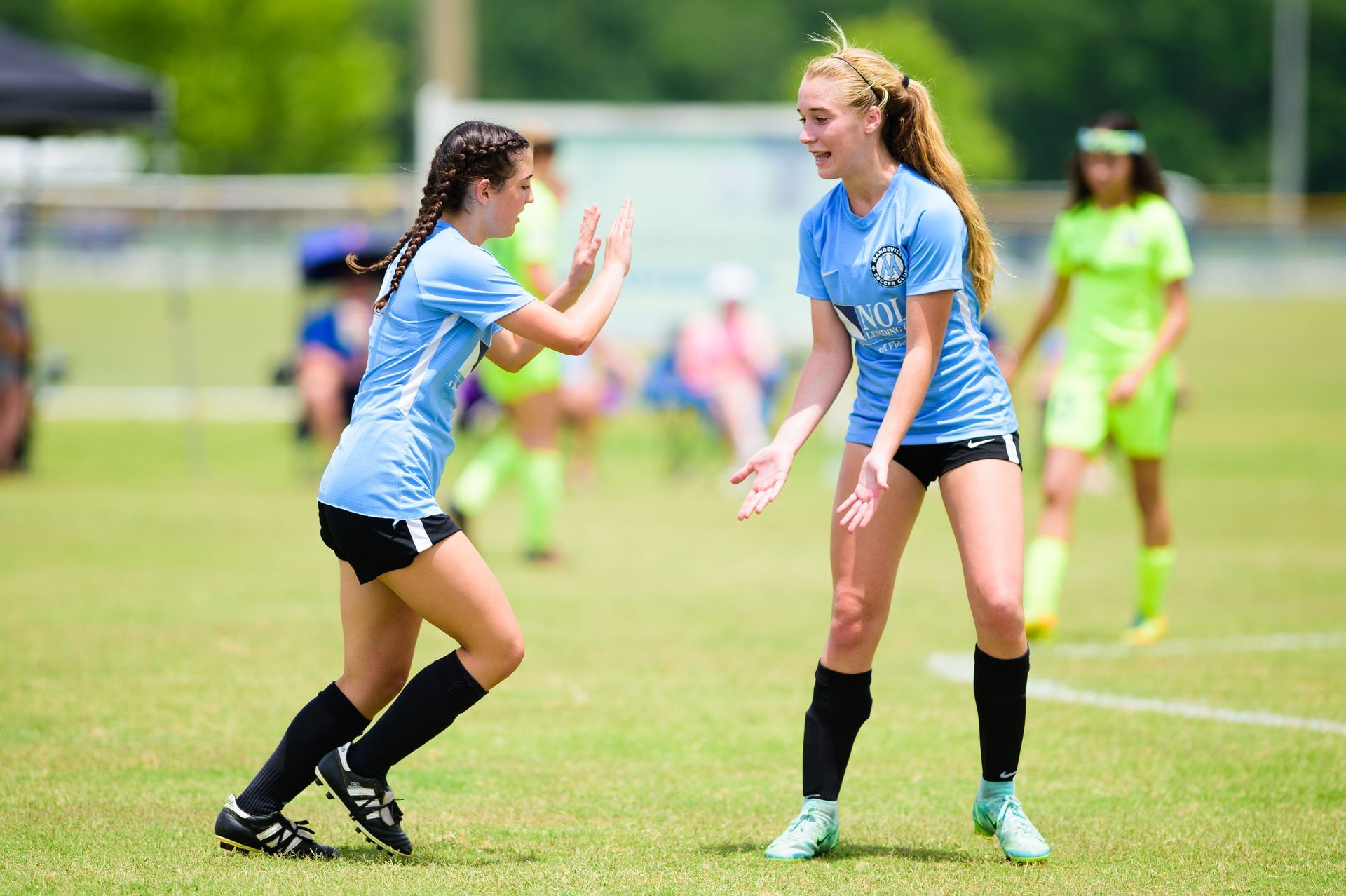 Two youth soccer players for Mandeville Soccer Club celebrating
