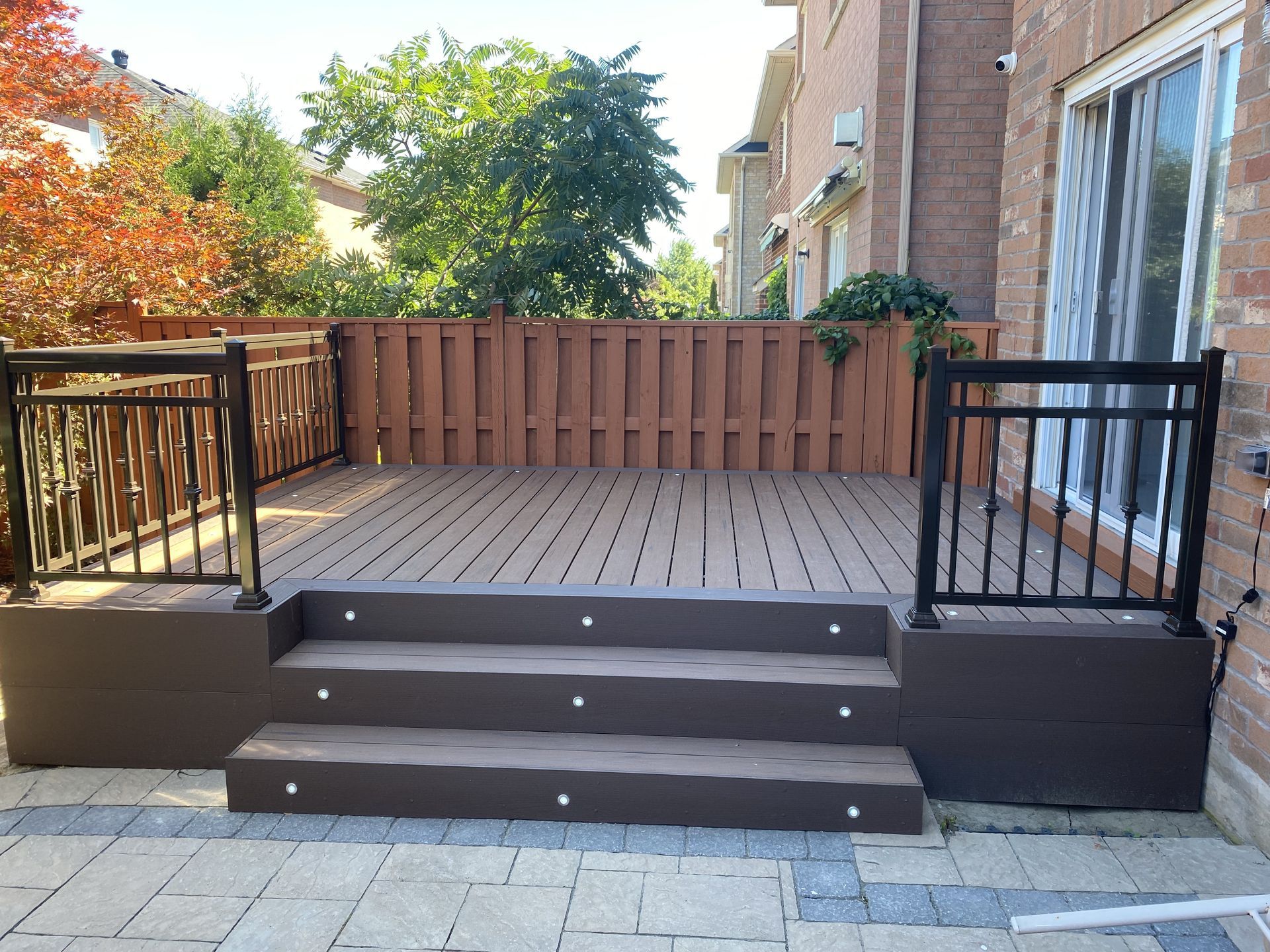 A wooden deck with stairs and a metal railing
