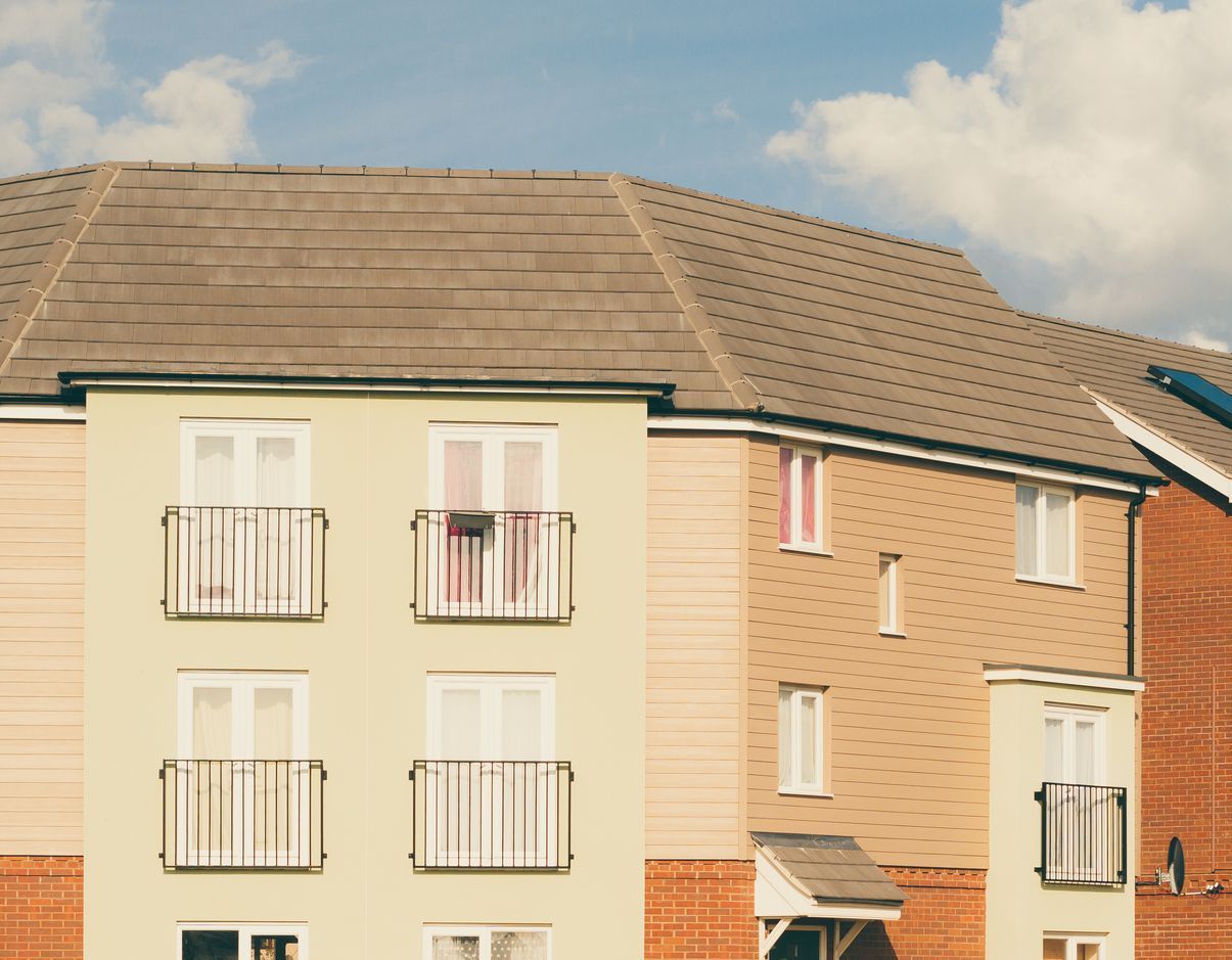 A row of houses with balconies and a blue sky in the background