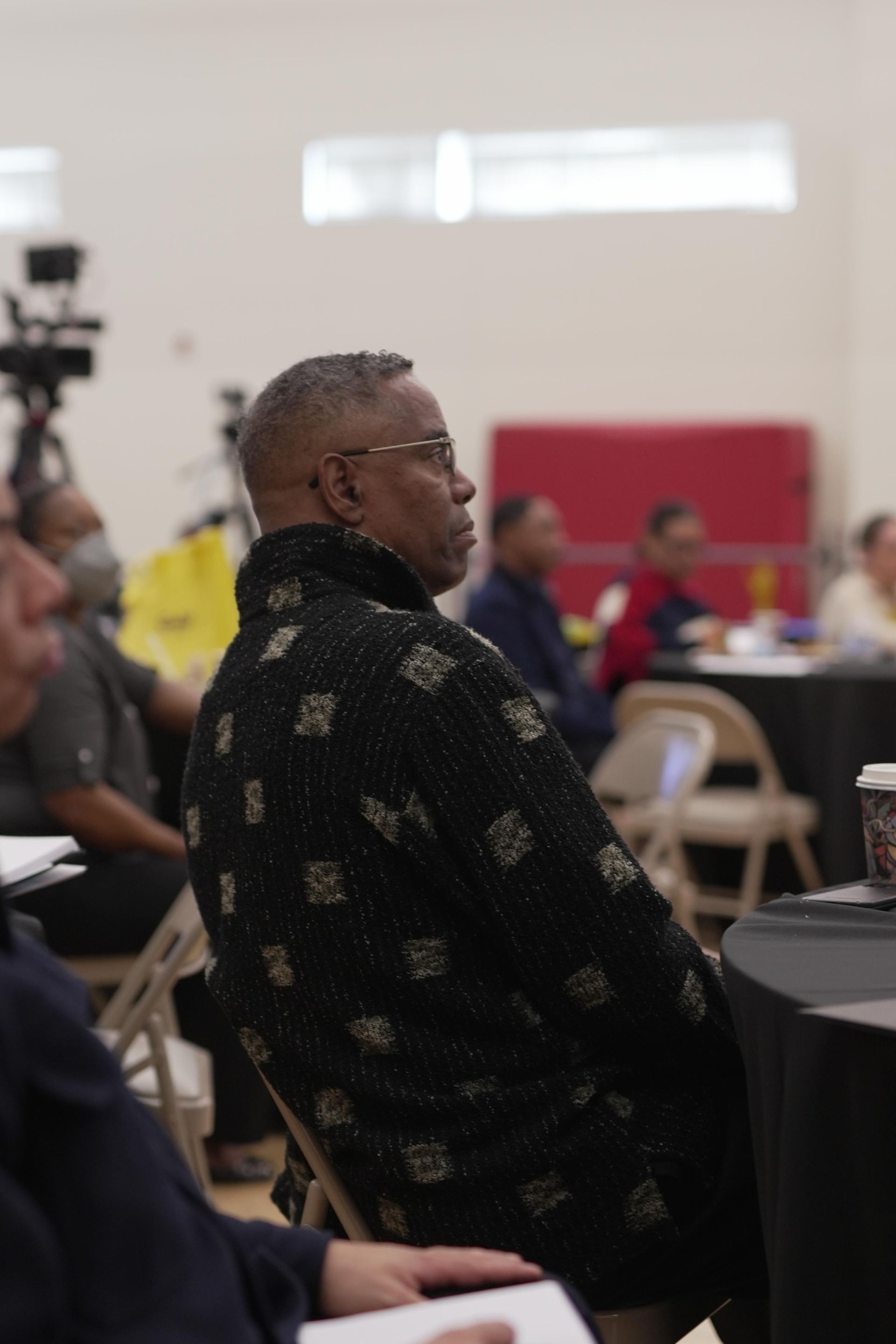 A man in a black shirt is sitting in a chair
