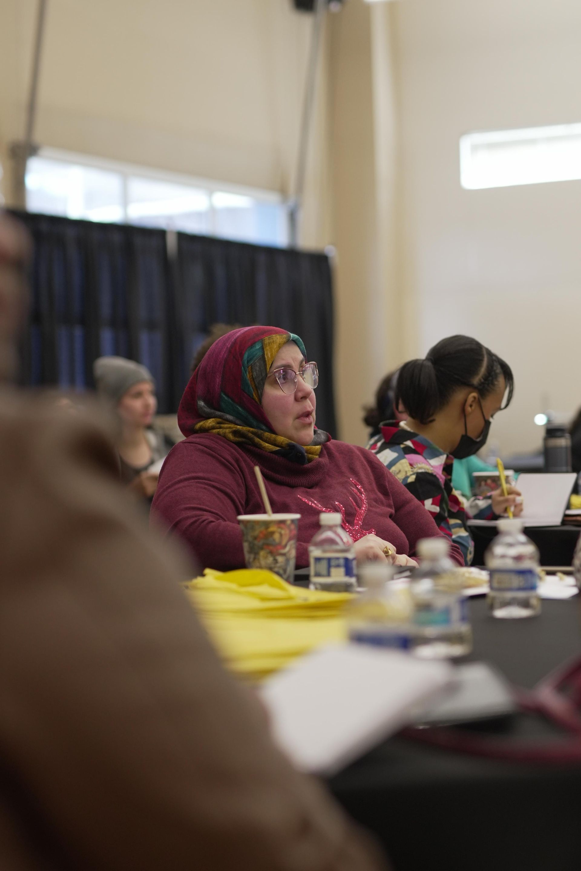 A group of people are sitting at tables in a room.