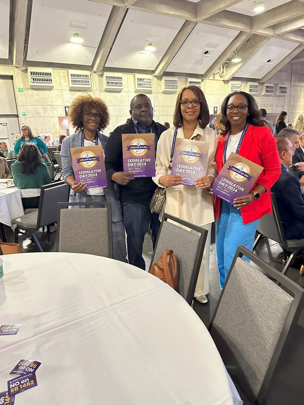 A group of people are standing around a table holding books.