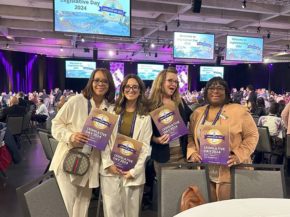 A group of women are posing for a picture at a conference.