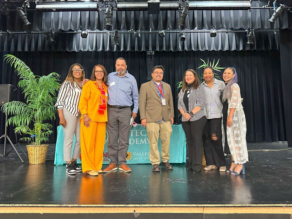 A group of people are posing for a picture on a stage.
