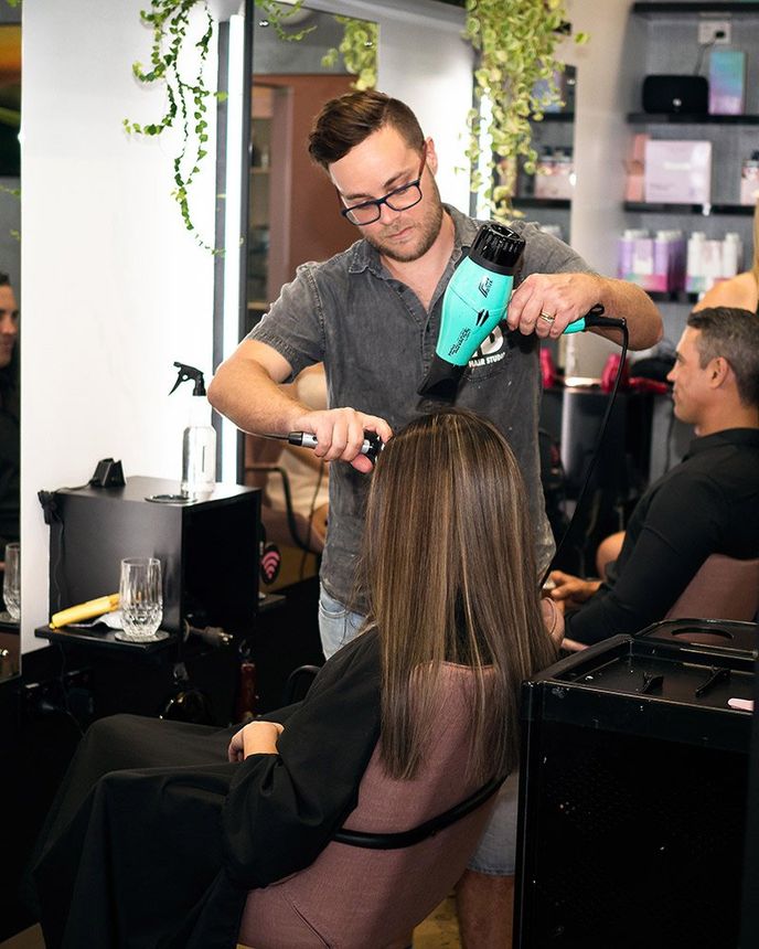 Hairdresser Blow Drying Hair in Hairdressing Salon — HD Hair Studio in Darwin City, NT