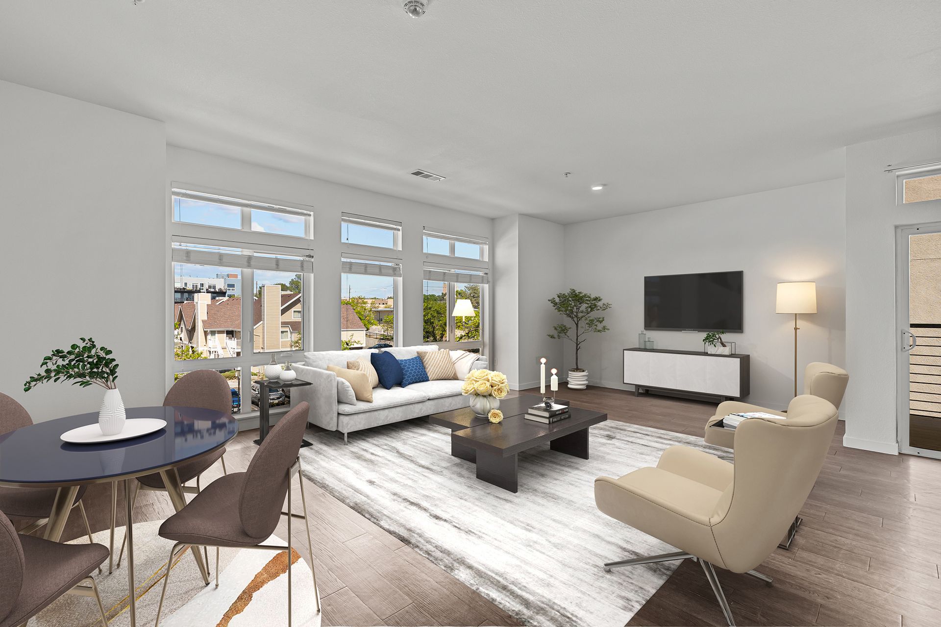 A living room with a couch , chairs , table and television.