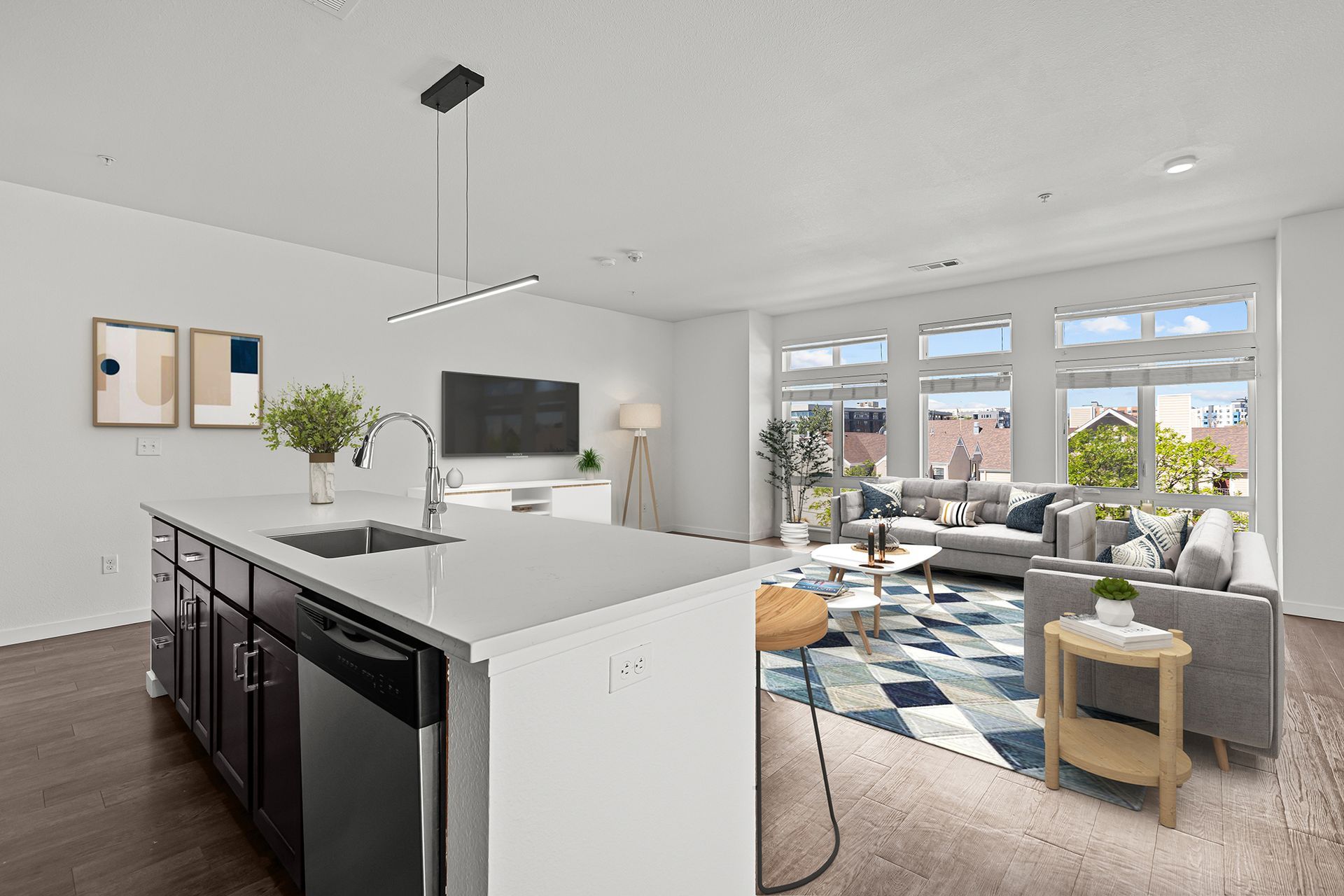 A kitchen and living room in a house with a large island in the middle.