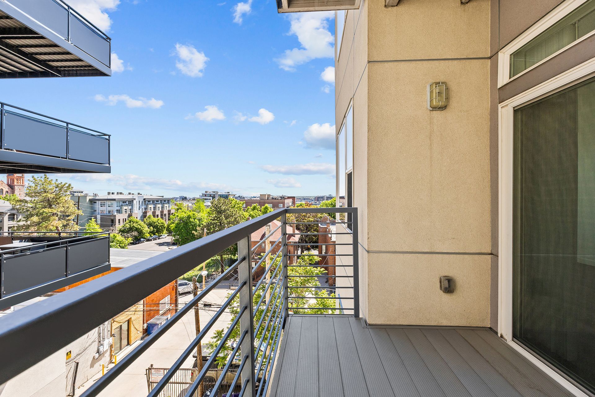 A balcony with a view of a city and trees