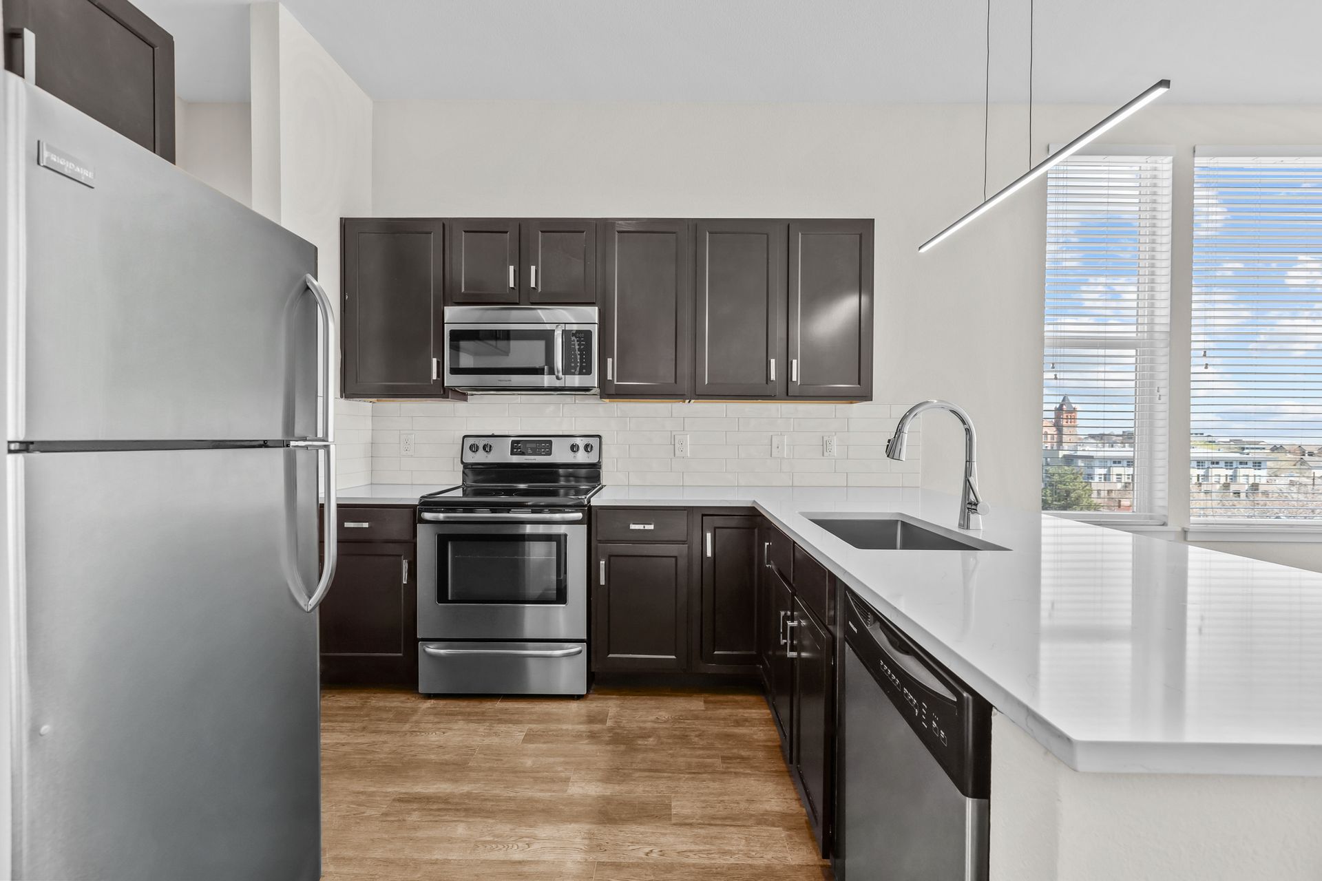A kitchen with a refrigerator , stove , microwave , sink and dishwasher.