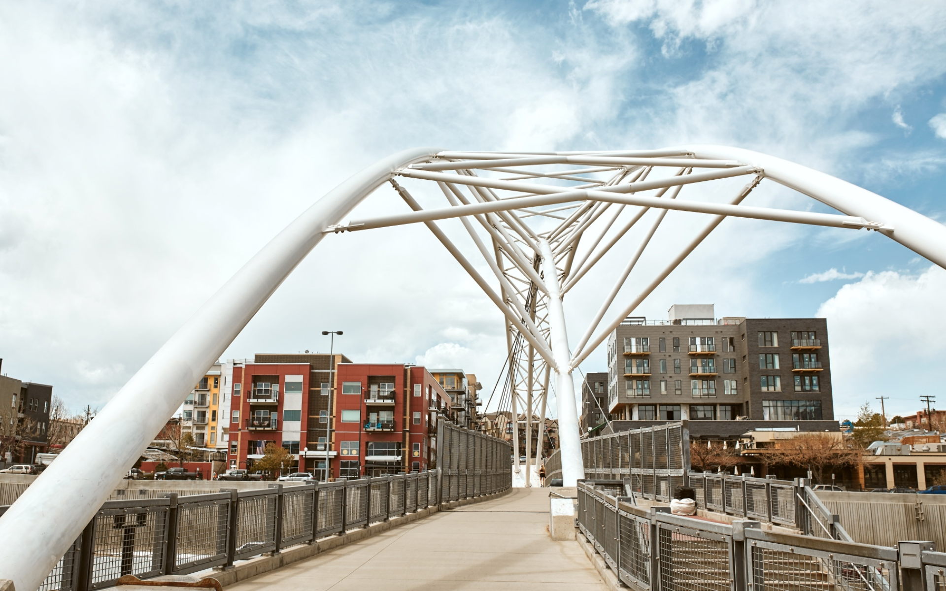 A bridge over a river in a city with buildings in the background.