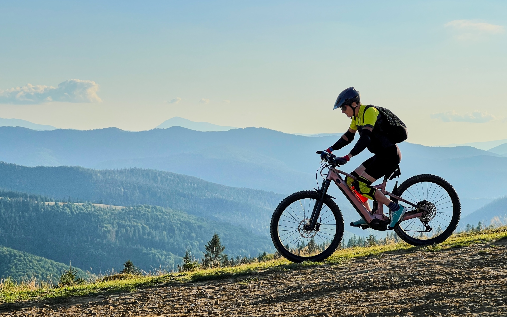 A man is riding a mountain bike on a dirt road.