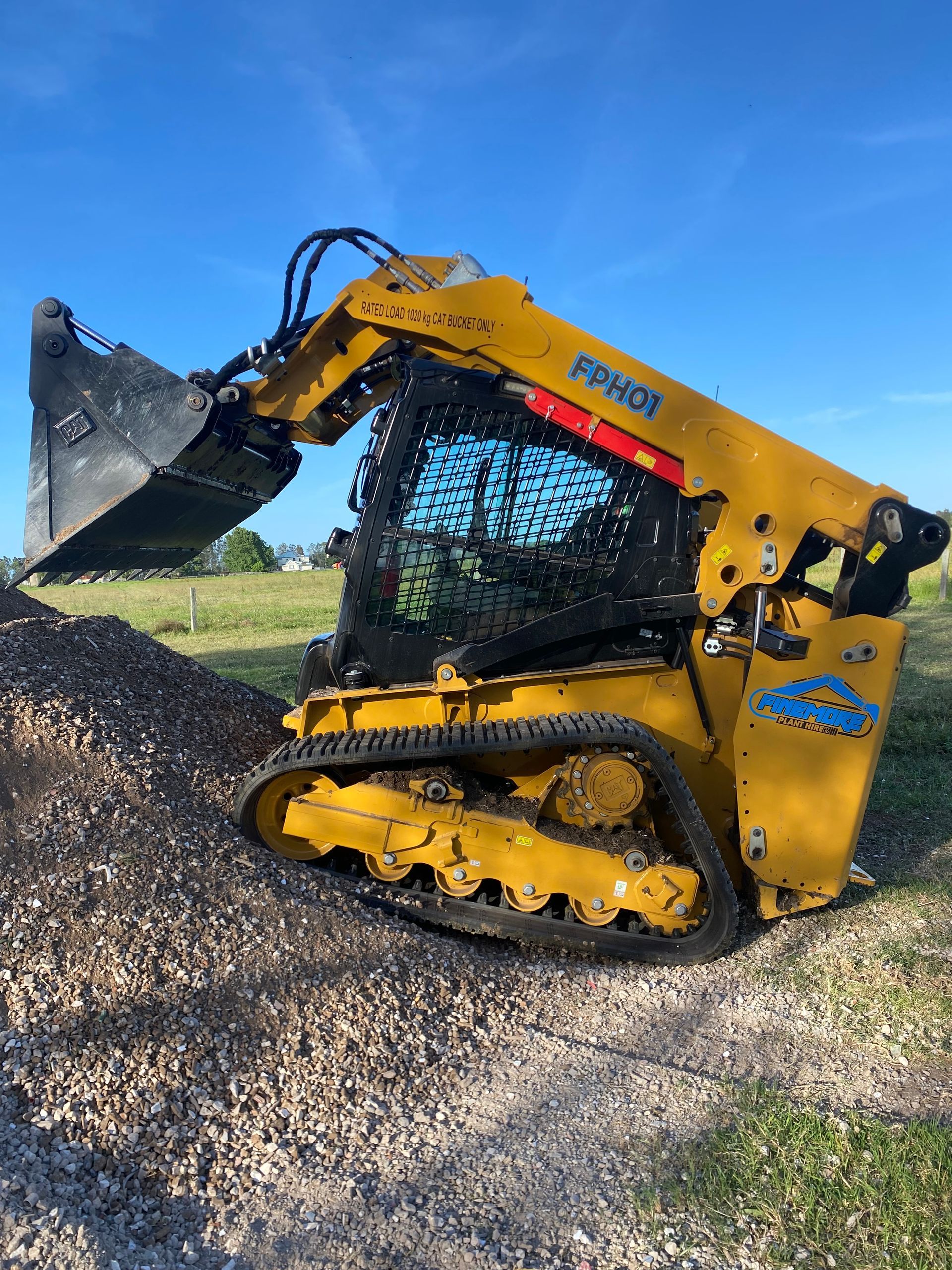 A bulldozer is parked in a parking lot in front of a building.