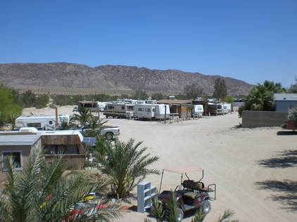 A golf cart is parked in the middle of a dirt road.