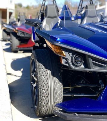 A blue slingshot is parked next to a red slingshot