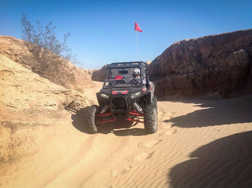 A person is riding a atv on a dirt road.