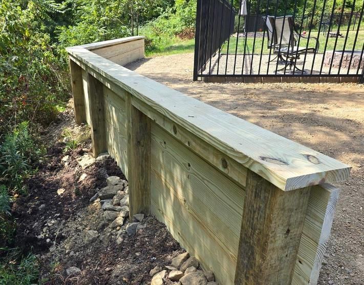 Stack of vertical slat replacement fence panels in a residential backyard, prepared for installation.