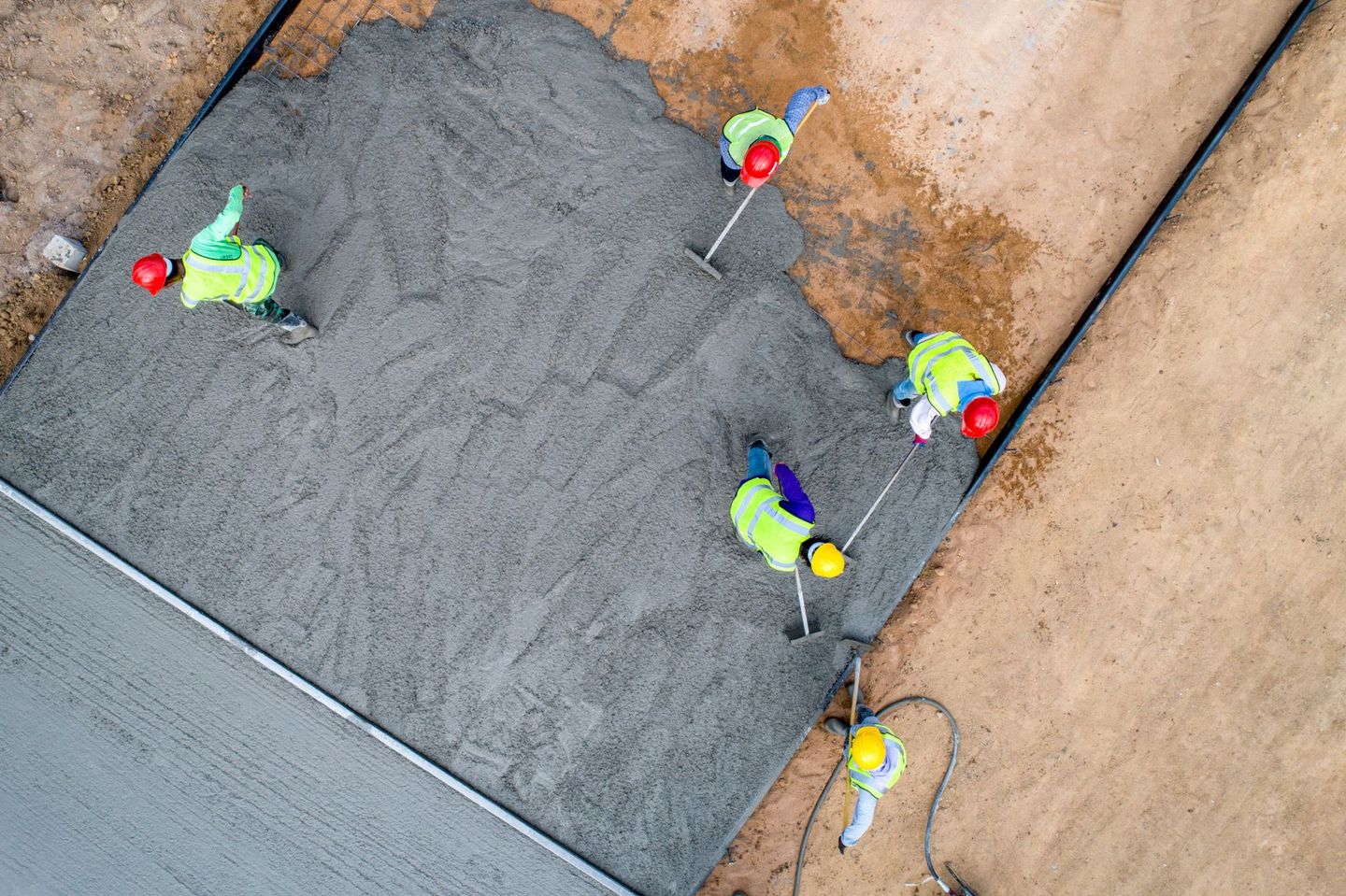 An aerial view of a group of construction workers laying concrete.