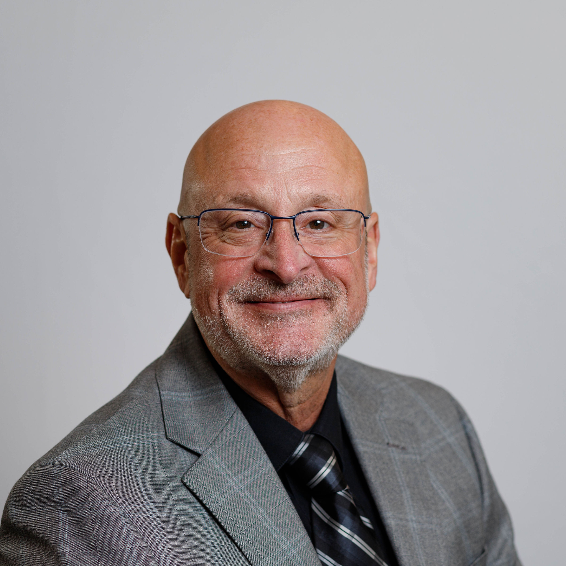 A man in a suit stands in front of a poster that says journey with us into the world